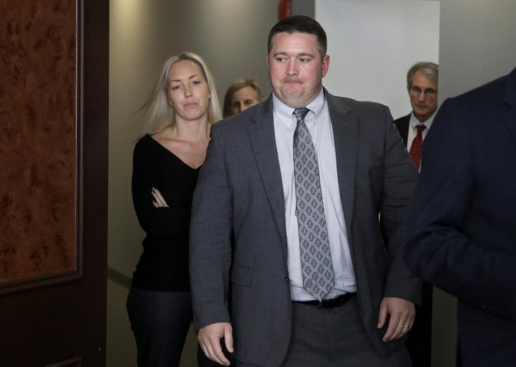 Boston police officer Kurt Stokinger, front, and his wife Janella Stokinger, left, enter a conference room before a news conference at a law office, Thursday, Oct. 18, 2018, in Boston. The officer is suing an online marketplace where the gun used to shoot him was sold. The lawsuit filed Thursday by the Brady Center to Prevent Gun Violence on behalf of officer Kurt Stokinger alleges that Armslist enables illegal gun sales and lacks safeguards to prevent guns from getting into the wrong hands. (AP Photo/Steven Senne) 