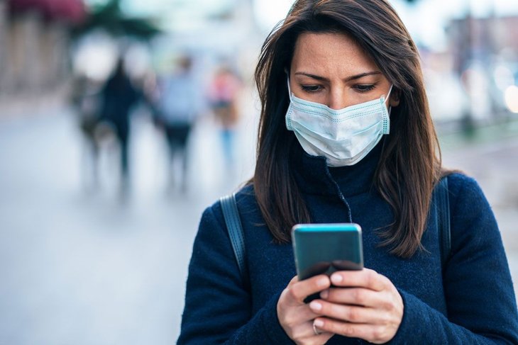 Women Using Cell Phone While Wearing Mask For Priv